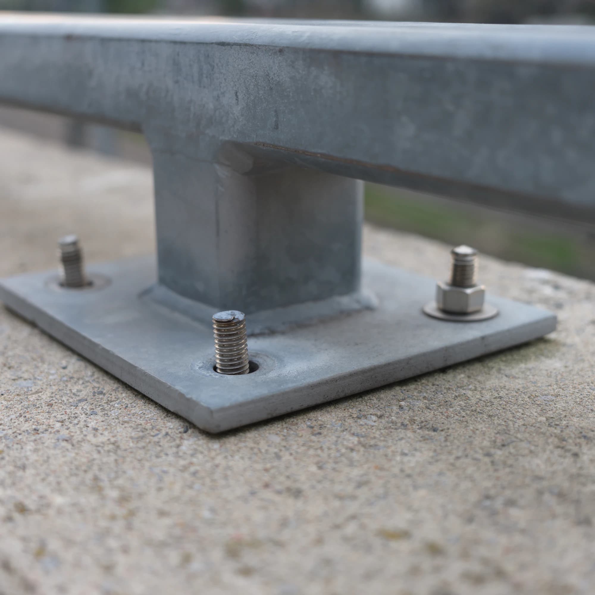Freshly poured concrete slab with anchor bolts set for a steel frame